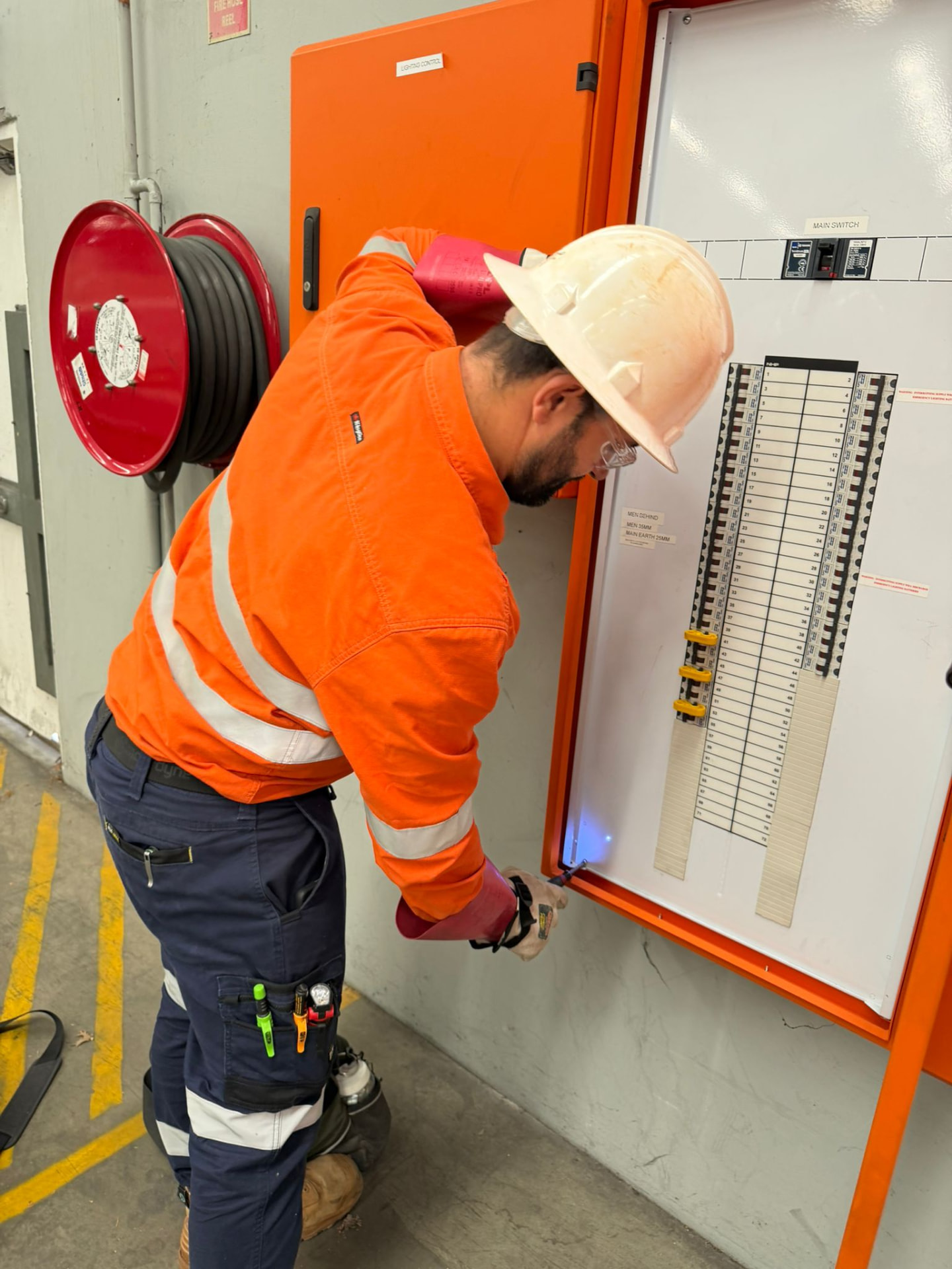Electrician inspecting a lighting control switchboard
