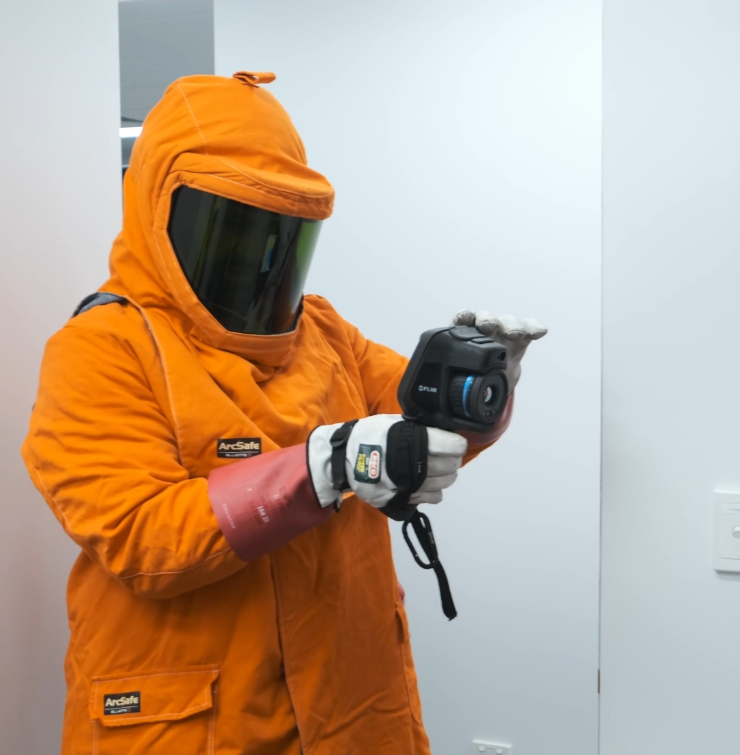 Thermographer in arc flash suit with FLIR camera