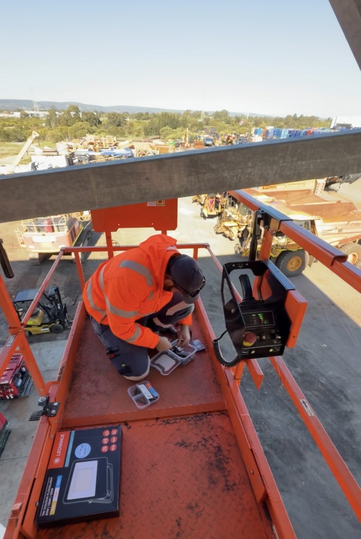 Electrician preparing a floodlight in a scissor lift basket
