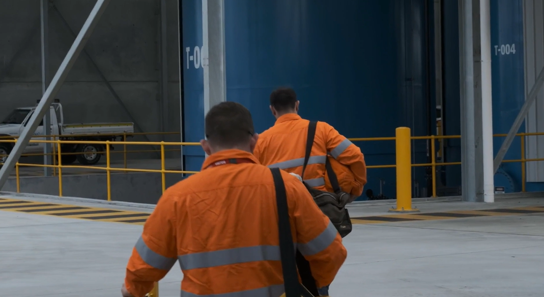 Electricians walking to a plant room on an industrial site